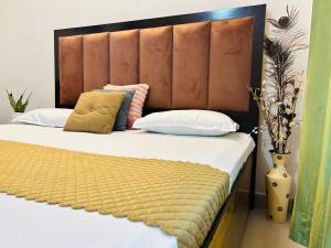 a bedroom with a large bed with a wooden headboard at Anandmay Homestay, Near Triveni Ghat, Rishikesh in Rishīkesh +21 photos
