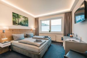 ein Hotelzimmer mit Bett und Schreibtisch in der Unterkunft Hotel Mukran in Sassnitz