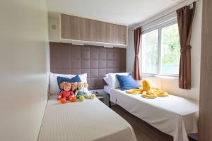 two beds with stuffed toys sitting on them in a room at Campeggio Paradiso in Sottomarina