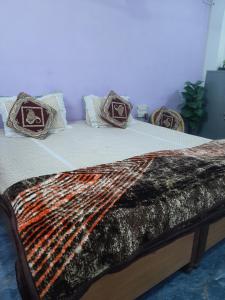 a bed with a comforter and pillows on it at Hotel Ashu , Ntl Road in Haldwāni +7 photos