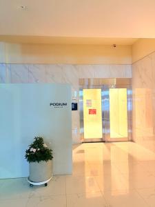 a potted plant in a lobby with two doors at 해변1분 숙소 광안이즘, 1 min to beach Gwangan-ism in Kwangan-dong
