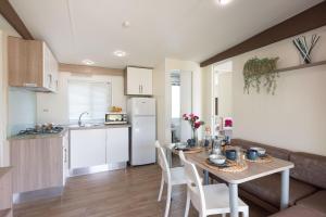 a kitchen and dining room with a table and chairs at Campeggio Paradiso in Sottomarina +54 photos