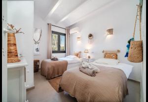 a bedroom with two beds with towels on them at La Finca Blanca Javea in El Tosalet +37 photos