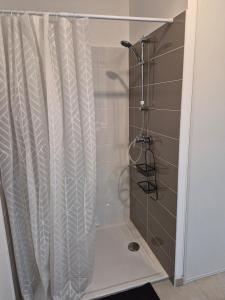a shower with a white shower curtain in a bathroom at Studio avec parking privé - Proche écoles & hôpital - Valence in Valence