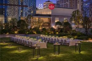 a long table with white tables and chairs in a field at Park Hyatt Changsha in Changsha