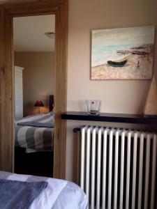 Zimmer mit einem Heizkörper, einem Bett und einem Gemälde in der Unterkunft Atrium in Ypern