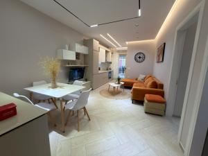 a living room and kitchen with a table and a couch at Onis Apartment in Vlorë