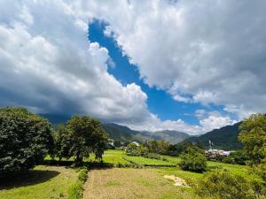 a field with trees and a cloudy sky at Anandmay Homestay, Near Triveni Ghat, Rishikesh in Rishīkesh