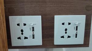two white electrical switches on a wooden wall at Pousada Lugama in Bento Gonçalves