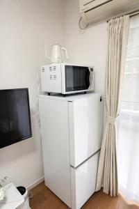 a microwave sitting on top of a refrigerator at ひまわり in Dazaifu