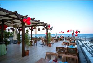 a restaurant on the beach with tables and chairs at Club Hotel Sunbel in Kemer