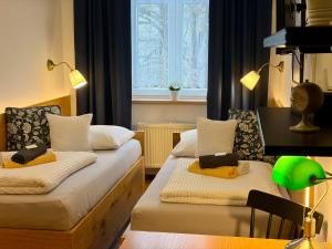 a small room with two beds and a window at Grand Tábor in Tábor