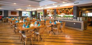 a restaurant with wooden tables and chairs and a bar at Club Hotel Sunbel in Kemer