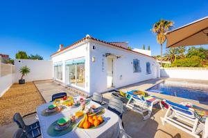a patio with a table and chairs and a swimming pool at Villa Kuki - PlusHolidays in Ifach