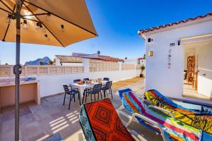 a patio with a table and chairs and an umbrella at Villa Kuki - PlusHolidays in Ifach