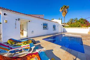 a villa with a swimming pool and two lounge chairs at Villa Kuki - PlusHolidays in Ifach