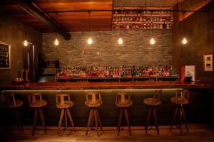 a bar with four stools in front of a bar at ホテル風の山 in Iida