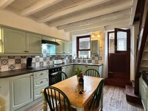 a kitchen with a wooden table with chairs and a tableablish at Gites Le Chezeau in Saint-Amand-Magnazeix