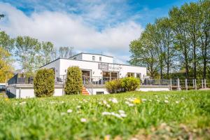 ein weißes Haus mit einem Garten davor in der Unterkunft Hotel Mukran in Sassnitz
