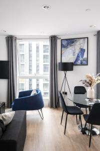a living room with a couch and chairs and a table at Apartment in MediaCity in Manchester