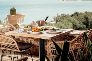 a table with plates of food and glasses of wine at Zeus Eleva Miraya in Agios Nikolaos