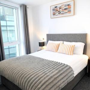 a bedroom with a large bed with a window at Apartment in MediaCity in Manchester