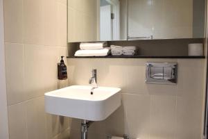 a bathroom with a sink and a mirror and towels at Apartment in MediaCity in Manchester +17 photos