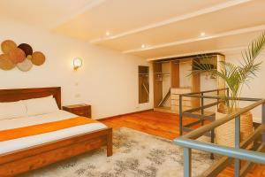 a bedroom with a bed and a staircase at Amaryllis Residences Mount Pleasant in Blantyre