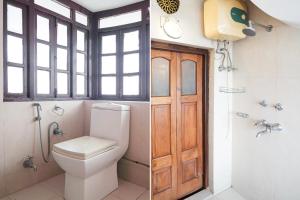 a bathroom with a toilet and a shower and a door at Palette by CheckIn Heritage Scindia Ghat in Varanasi +60 photos