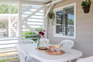 a white table and chairs on the porch of a house at Campeggio Paradiso in Sottomarina