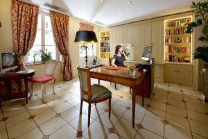 a woman sitting at a desk in a room at Le Relais Montmartre in Paris