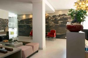 a living room with a couch and red chairs at Hotel Douro Inn in Tabuaço