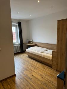 a bedroom with a bed and a wooden floor at Gasthaus - Hotel Neue Post in Meitingen