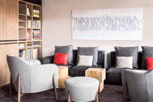 a living room with couches and chairs and a book shelf at White 1921 Courchevel in Courchevel
