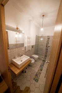 ein Badezimmer mit einem Waschbecken, einem WC und einem Spiegel in der Unterkunft Ovo - Slow Travel in Neapel