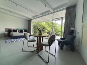 a living room with a table and chairs and a bed at Lighthouse Bingin - 360 view in Uluwatu