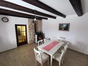 a dining room with a white table and chairs at Holiday House - Hidden in Velebit in Senj