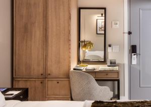 a room with a bed, chair, desk and a mirror at HGU New York in New York