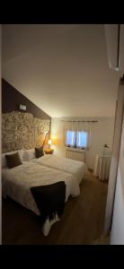 a bedroom with a large bed and two windows at Casa rural marga in Tardienta