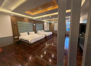 a bedroom with two beds and a television in it at Hotel Town Star in Srinagar +10 photos