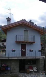 a white house with a balcony and a porch at Casa Vacanze Chez Sapin in Fenis