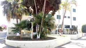 una señal de hotel frente a una palmera en Diplomata Hotel, en Araras