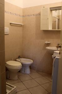un baño con inodoro y lavabo en Appartamenti Tra gli Ulivi, en Bardino Nuovo