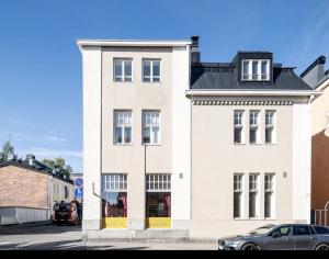 a white building with a black roof at Tunnelmallinen saunallinen ullakkohuoneisto Ravintola Sampon yläkerrassa in Kuopio
