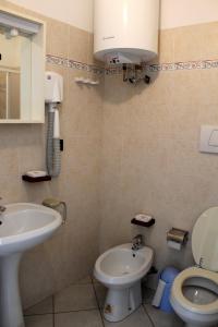 un baño con inodoro y lavabo en Appartamenti Tra gli Ulivi, en Bardino Nuovo