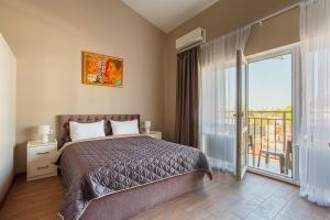 a bedroom with a large bed and a balcony at Five seasons Family in Odesa