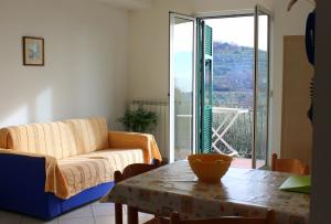 una sala de estar con un sofá y una mesa en Appartamenti Tra gli Ulivi, en Bardino Nuovo