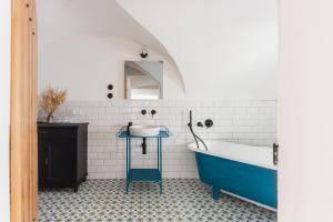 a bathroom with a blue tub and a sink at Am Znaimertor in Retz