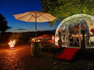 a marquee with an umbrella and a table with lights at Nordenholzer Hofhotel in Hude