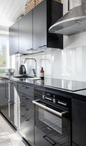a kitchen with stainless steel appliances and a stove at Tunnelmallinen saunallinen ullakkohuoneisto Ravintola Sampon yläkerrassa in Kuopio